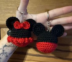 two crocheted mickey and minnie mouse keychains on a person's arm