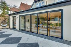 an outdoor patio with sliding glass doors leading into the back yard and dining room area