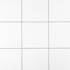 a white tiled wall with several different sized tiles on the bottom and one in the middle