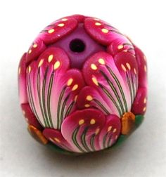 a pink flower bead sitting on top of a white surface