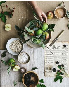 the table is covered with apples and other ingredients