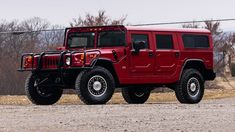 a red hummer truck parked on the side of a road