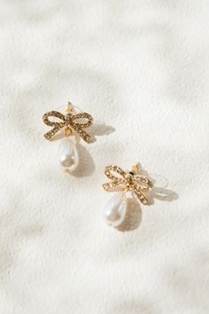 Add some feminine charm to any outfit with these Dainty Crystal Bow with Pearl Drop Earrings. Featuring a sparkly jeweled bow on a stud and a delicate teardrop shaped pearl, these lightweight earrings are sure to elevate your look. The post with a bullet clutch back ensures a secure, perfect fit. White Dress Party, Lightweight Earrings, Shoe Gifts, Pretty Earrings, Elevate Your Look, Light Weight Earrings, Kids Jewelry, Pearl Drop Earrings, Pearl Drop