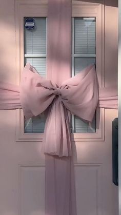 a pink bow hanging from the side of a door