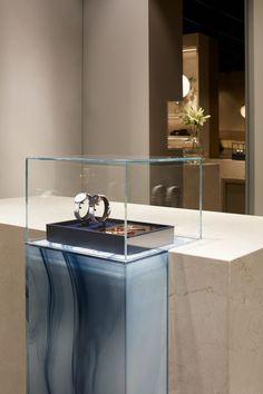 a clock sitting inside of a glass case on top of a counter