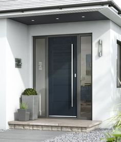 the front door to a modern home with potted plants