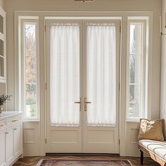 a large white door with two windows and a rug on the floor in front of it