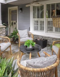 a patio with wicker furniture and potted plants