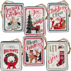 four cross stitch coasters with christmas designs on them