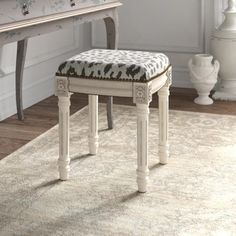 a white bench sitting on top of a rug in front of a desk and chair