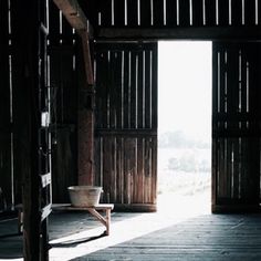 an open door leading into a room with wooden walls and flooring on both sides