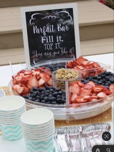 a table topped with plates and cups filled with fruit next to a sign that says parfait bar fill it top it