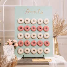 a table with donuts on it next to a sign that says donuts and flowers