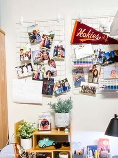 a desk with several pictures hanging on the wall