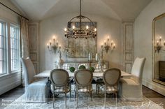 an elegant dining room with chandelier, chairs and rugs on the floor