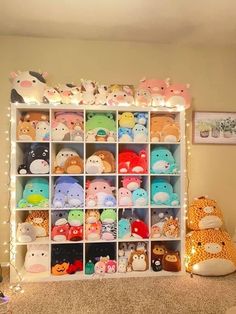 a room filled with lots of stuffed animals next to a wall mounted shelf full of lights