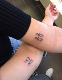 two people with matching tattoos on their arms