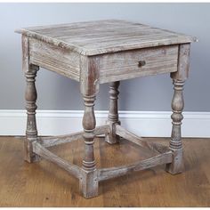 an old wooden side table with turned legs