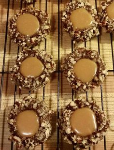 chocolate covered cookies sitting on top of a cooling rack with peanut butter in the middle