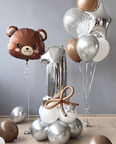 a teddy bear and some balloons on a table