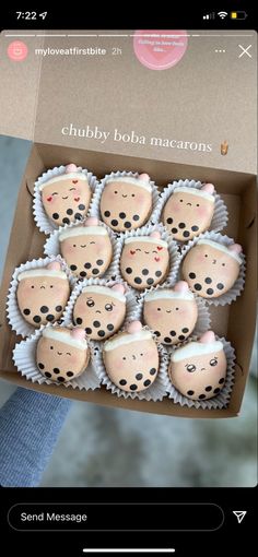 someone is holding a box full of cupcakes that look like they have faces on them