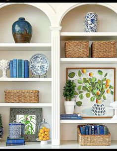 two white shelves filled with books and vases