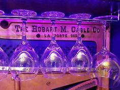 several wine glasses are lined up in front of a purple sign that says the robert m gle co