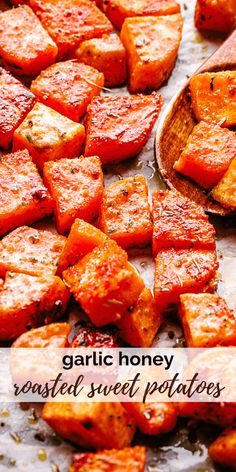 roasted sweet potatoes on a baking sheet with text overlay that reads garlic honey roasted sweet potatoes