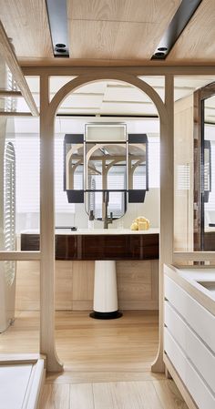 the interior of a bathroom with wooden floors and white fixtures on the walls, along with an oval shaped mirror