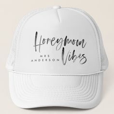 a white trucker hat with the words honeymoon vibes written on it in black ink