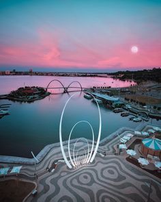 an aerial view of a marina with boats in the water at sunset or dawn,