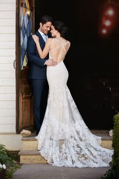 a bride and groom standing in front of a door