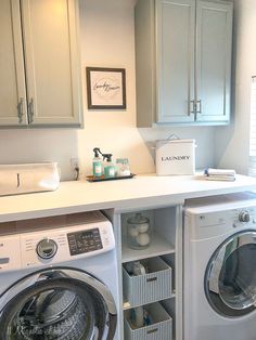 a washer and dryer in a room with cabinets on the wall above them