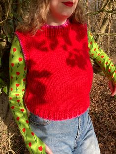 Handmade sweater vest made to measure in lush red and pink. Hand knitted by me from 100% wool so it's super warm and stretchy.  Mock neck style around the neck for extra cosiness. Looks great styled over a long sleeve top, a dress or even layered over another jumper!  Can be ordered with or without the heart embroidery- please select from the drop down menu. Please allow 3-4 weeks for your order to be made and dispatched. Measurements I will need BEFORE I can start making your order: - Bust (widest part of the chest)  - Length you would like the vest (from top of shoulder to hem) If you would like different colours just send me a message and we can discuss options!  Free worldwide delivery.  Hand wash only, dry flat. Pink Crew Neck Vest For Spring, Fitted Knit Vest For Winter, Fitted Winter Sweater Vest, Fitted Sweater Vest For Winter, Knit Vest For Winter, Red Knit Sweater Vest For Spring, Pink Stretch Sleeveless Sweater Vest, Fitted Pink Sweater Vest For Fall, Fitted Red Sweater Vest For Spring