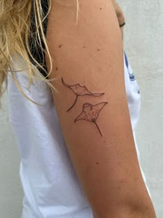 a woman's arm with a tattoo on it that has an image of a bird