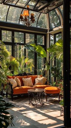 an orange couch sitting in the middle of a living room filled with lots of plants