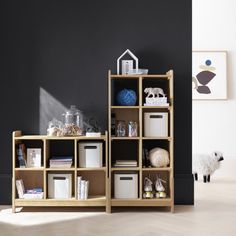 a room with black walls and wooden shelves filled with books, toys and other items