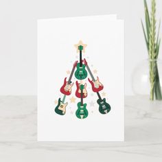 a christmas card with guitars and stars in the shape of a tree on white paper