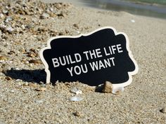 a sign on the sand that says build the life you want to live in it