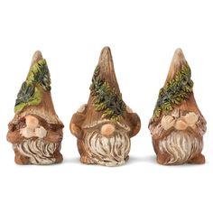 three figurines of gnomes with green leaves on their heads and beards