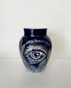 a blue vase with an eye painted on it