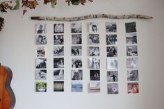 a wall with many pictures on it and a guitar hanging from the wall next to it