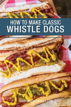 three hot dogs with mustard and ketchup on them sitting on top of a checkered table cloth