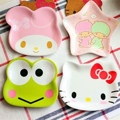 hello kitty and frog shaped plates on a checkered tablecloth