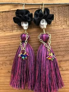 two pairs of purple tassels with skulls on them