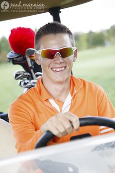 a man in an orange shirt driving a golf cart