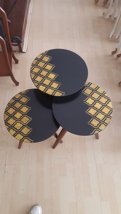 three black and yellow tables sitting on top of a wooden floor