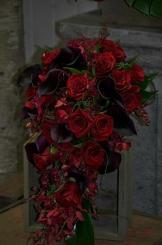 a bouquet of red roses and purple orchids