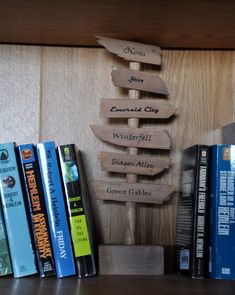 a shelf with books and wooden signs on it