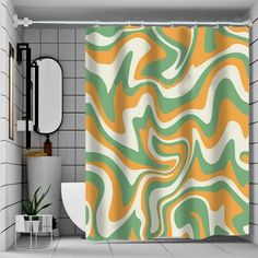 a bathroom with a shower curtain that has an orange and green pattern on it